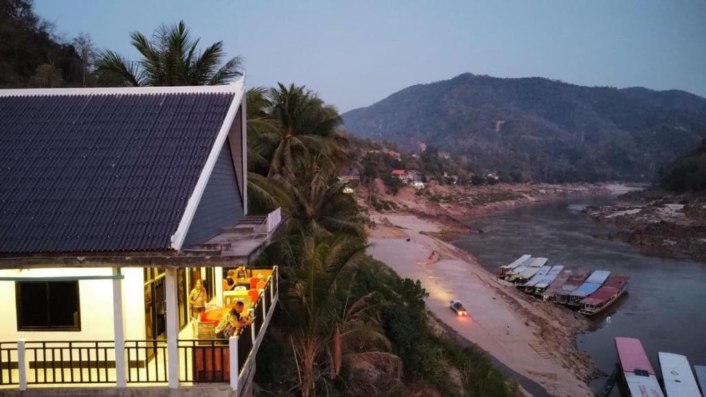 un hotel con vistas al río y a la playa en INN RIVERSIDE HOSTEL Pb, en Pakbeng