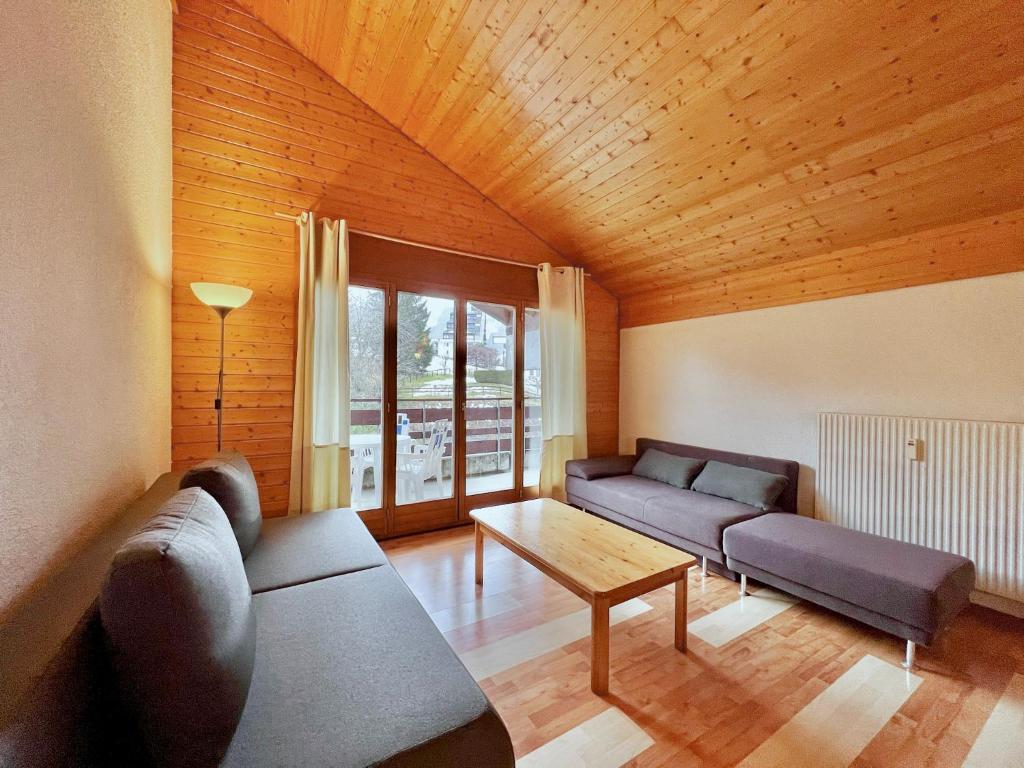 a living room with two couches and a table at Appartement pour 8 terrasse et Parking in Vionnaz