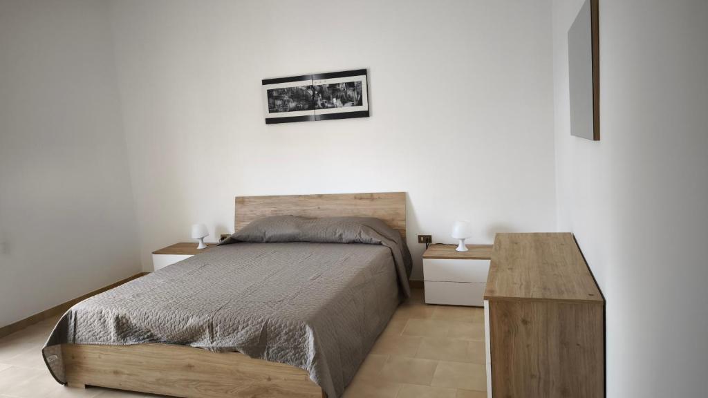 Un dormitorio con una cama y una mesa de madera. en Vitachiara apartment, en Santa Ninfa