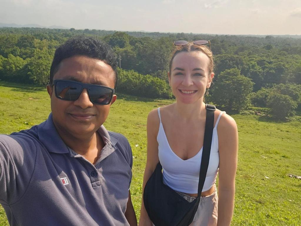 un homme et une femme se tenant dans un champ dans l'établissement Cinnamon Villa Weligama, à Weligama