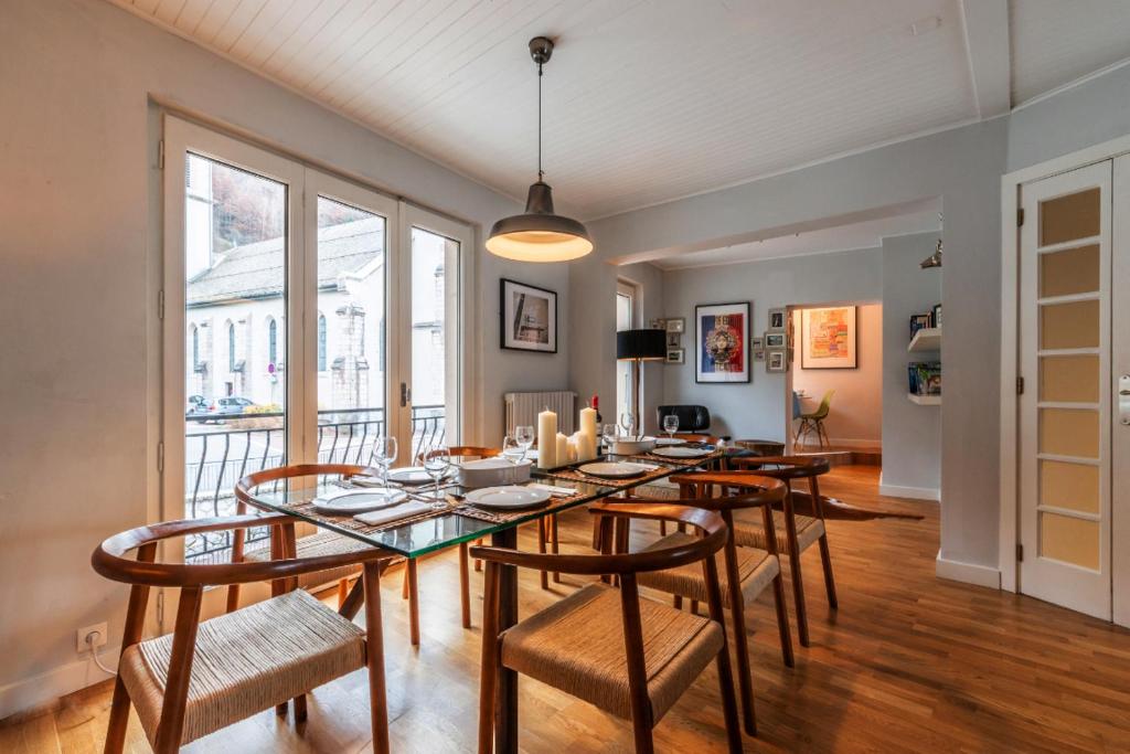 une salle à manger avec une table et des chaises en verre dans l'établissement Le Grenier, à Saint-Jean-dʼAulps