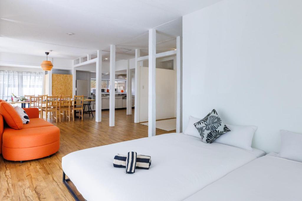 a bedroom with a bed and a couch and a dining room at プライベートサウナでととのうpono 118は今帰仁村にあるお庭付き一棟貸 in Nago