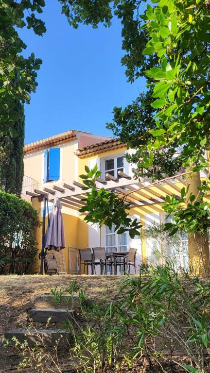 une maison avec une terrasse et un parasol dans l'établissement Les Restanques 10 Chenes 3 chambres, à Grimaud