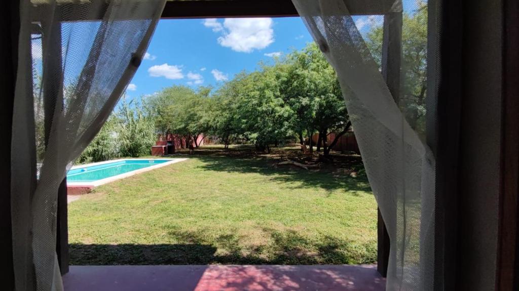 a window view of a yard with a swimming pool at Finca con pileta Lasmaria in Santiago del Estero