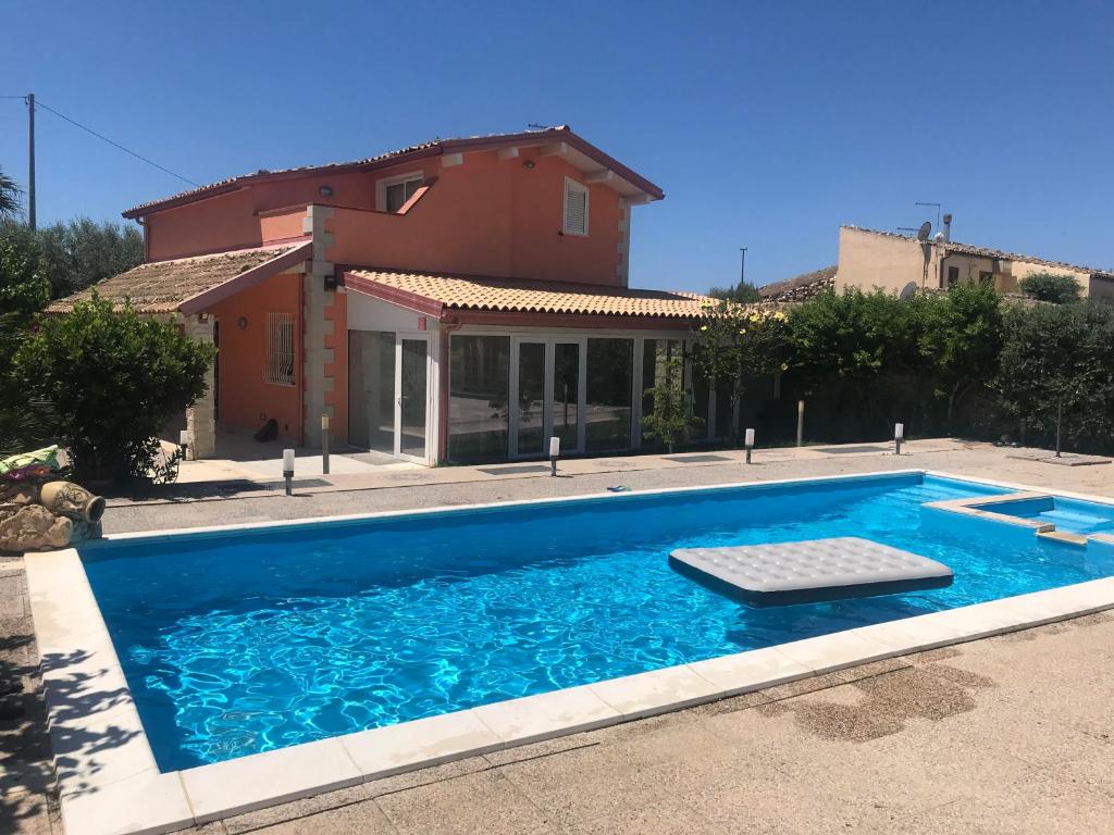 a swimming pool in front of a house at Lovely Independent Villa in Plaia Grande