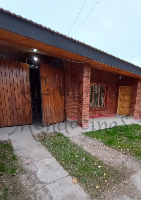 a brick building with two garage doors on it at Hospedaje Cumbres Mendocinas-Depto Aconcagua in San Rafael