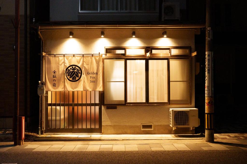 un edificio con cancello di notte con luci di Golden Fox Inn, Old house in the old city, Walking distance to Matsumoto Castle and tourist attractions a Matsumoto