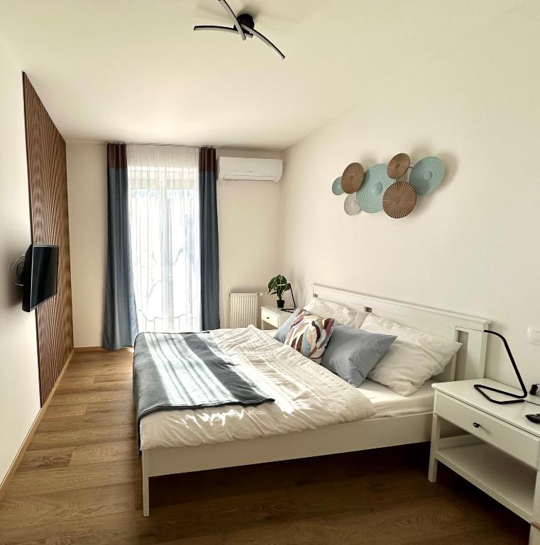 a bedroom with a bed and a desk with a lamp at Falcon Apartman Tatabánya in Tatabánya