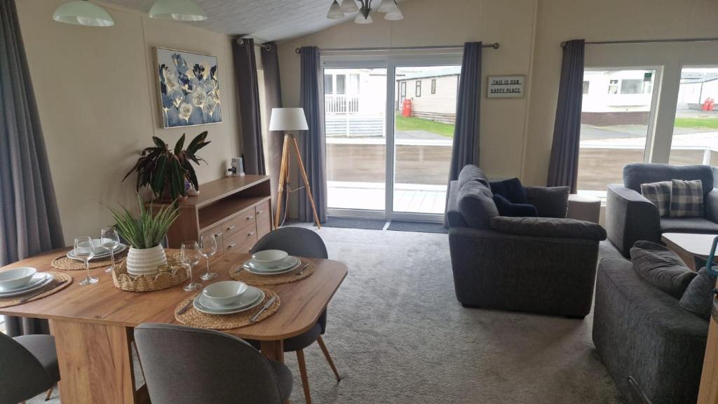 een woonkamer met een houten tafel en stoelen bij Coastal Retreat Lodge in Morecambe