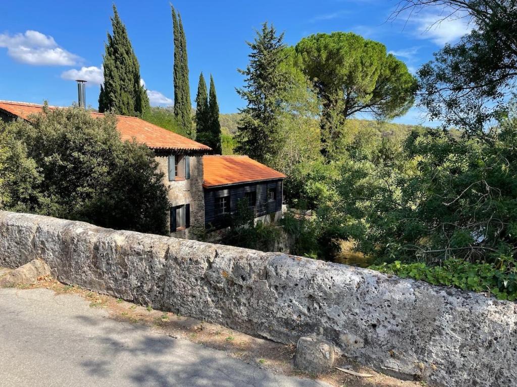un vieux mur en pierre devant une maison dans l'établissement Le Moulin, au Muy