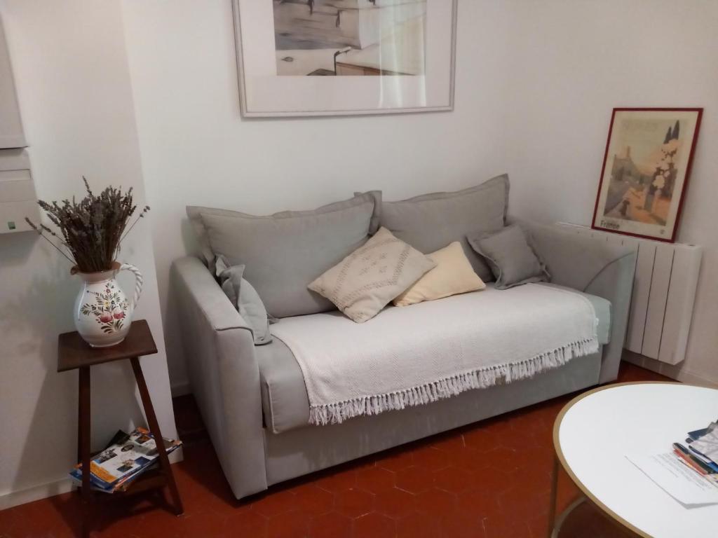 un canapé avec des coussins dessus dans un salon dans l'établissement les garrigues, à Nîmes