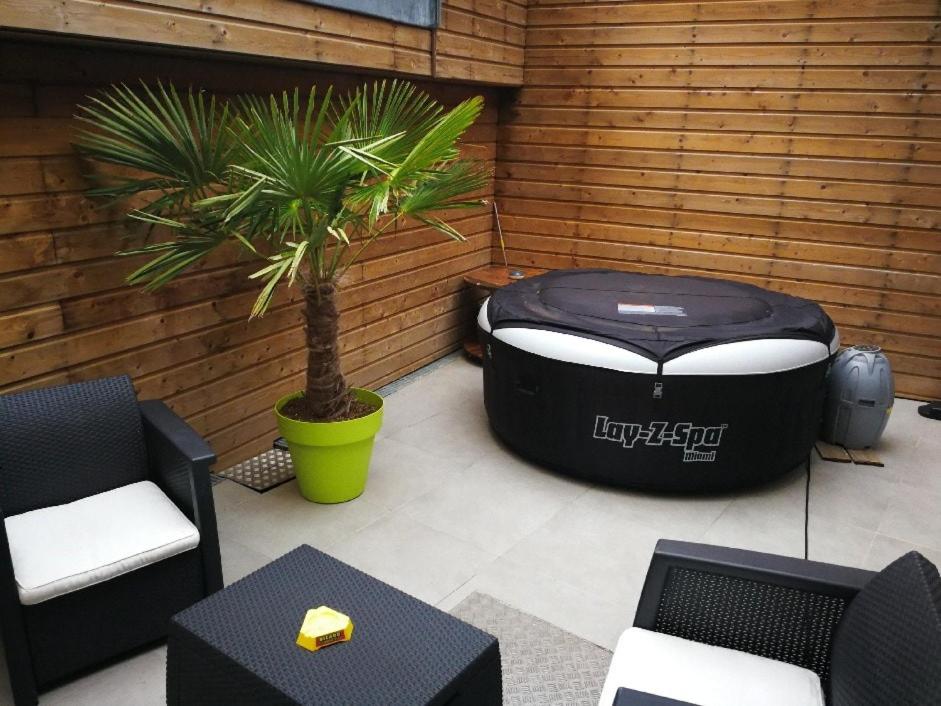 une terrasse avec un grand pouf et un palmier dans l'établissement Agréable maison de ville au coeur de Troyes, à Troyes