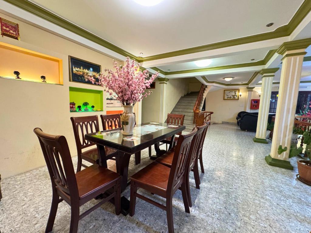 a dining room with a table and wooden chairs at Nhat Quynh Hotel in Da Lat