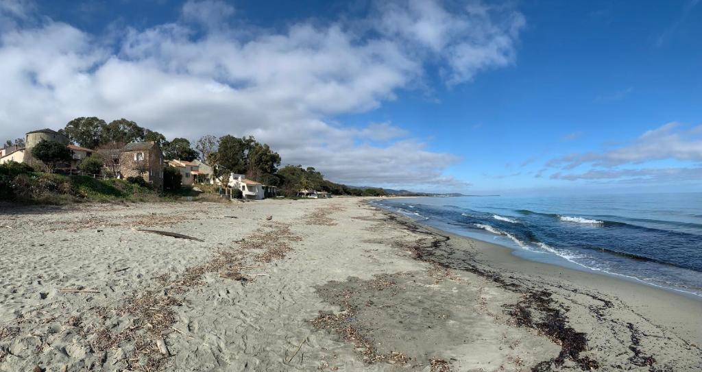 une plage vide avec des maisons et l'océan dans l'établissement Villa Costa Verde, à Cervione