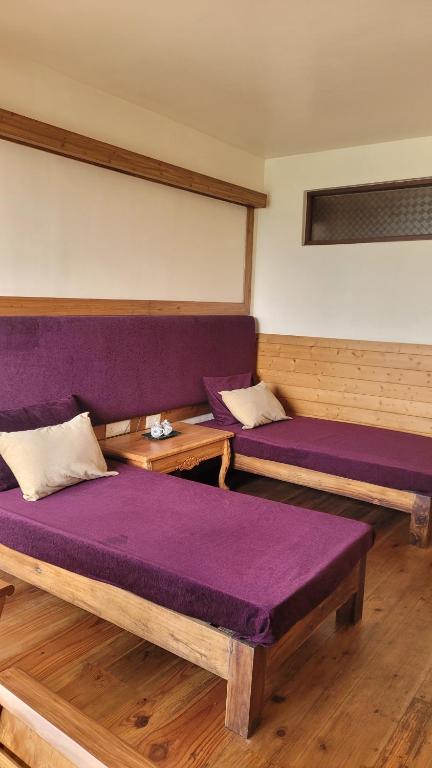 two beds in a room with purple cushions at Tara Homestay in Darjeeling