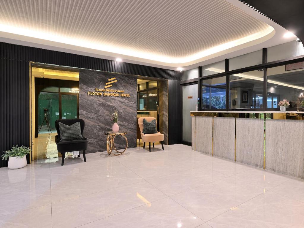 a lobby with two chairs and a bar in a building at Floton Bangkok Hotel in Bangkok