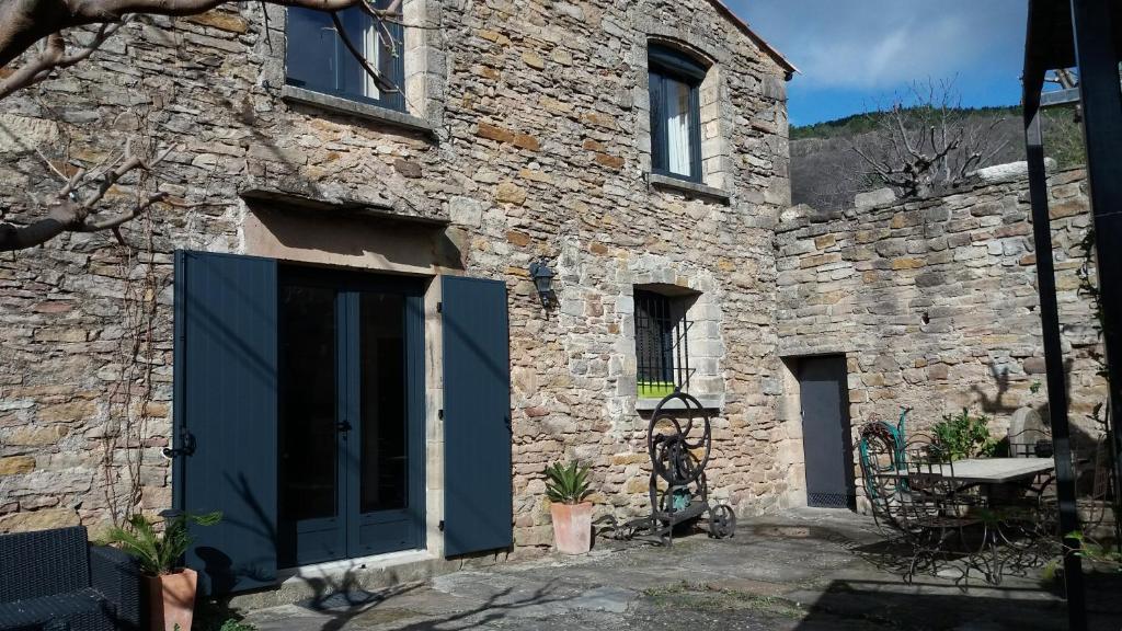 - un bâtiment en pierre avec une porte bleue dans l'établissement Gîte La Remise 6 pers. du samedi au samedi, à Saint-Privat