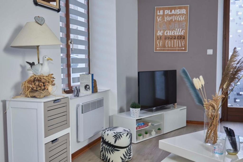 Il comprend un salon avec un bureau et une télévision. dans l'établissement Appartement au pied des remparts avec place de parking, à Boulogne-sur-Mer