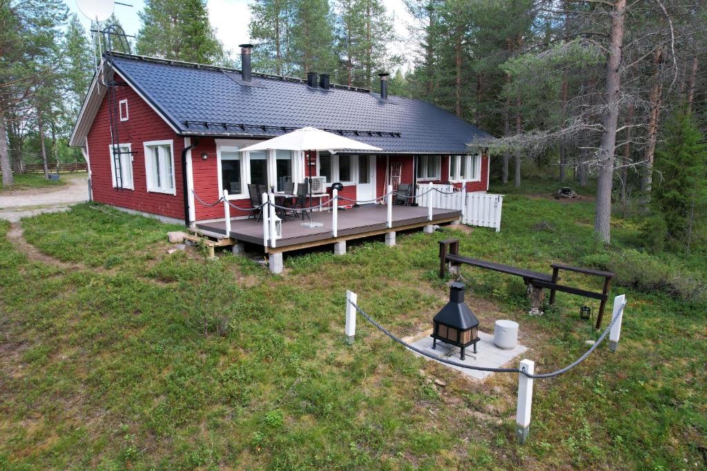 a red house with a porch in the grass at Villa Kiviaapa in Ruka Kuusamo in Ruka