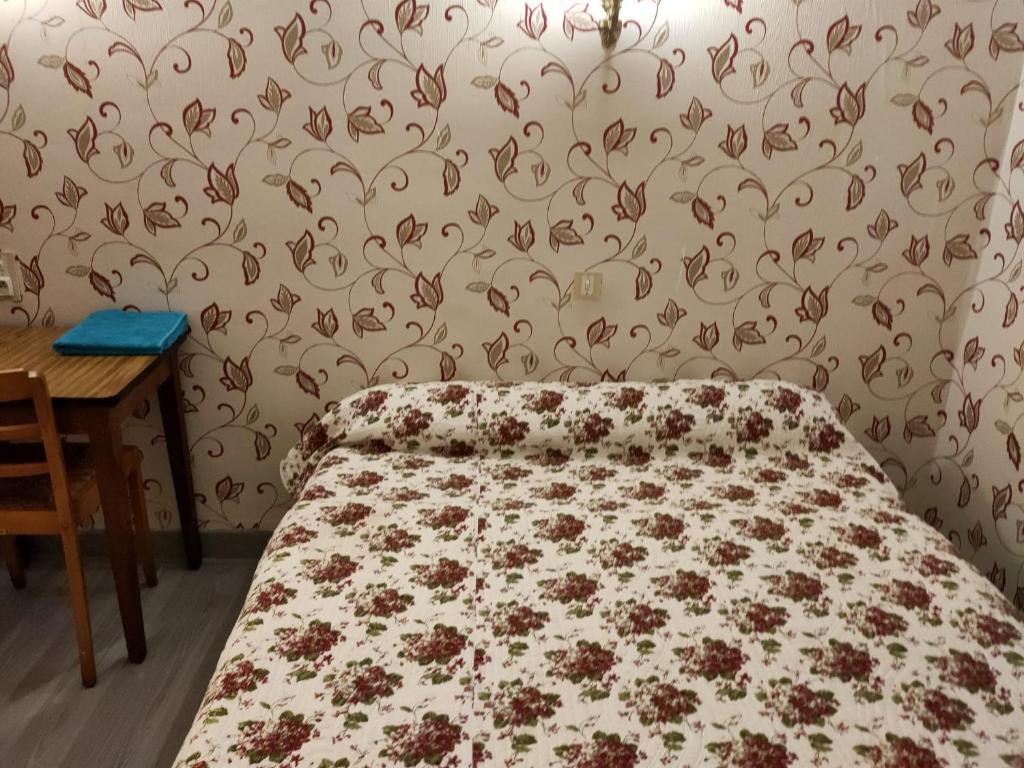 - une chambre dotée d'un lit avec un motif floral sur le mur dans l'établissement hotel saint fracois xavier, à Lourdes