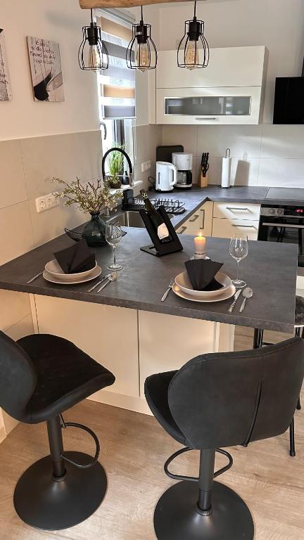 a kitchen with a table with plates and wine glasses at Ferienhaus Roßbachtal in Biberschlag