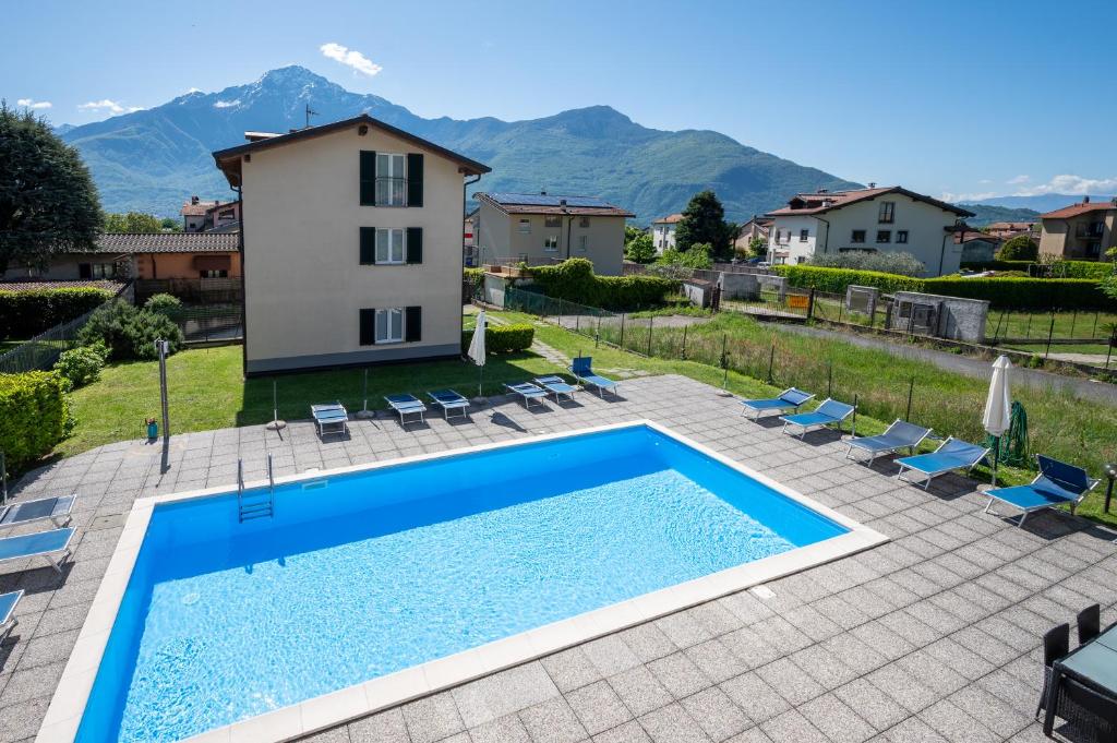 a villa with a swimming pool and mountains in the background at My Holidays New Eden Mansarda in Domaso