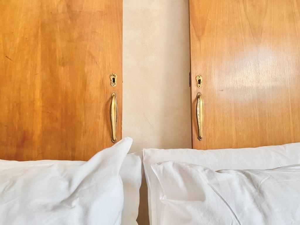 a bed with white sheets and a wooden headboard at CASì in Noto