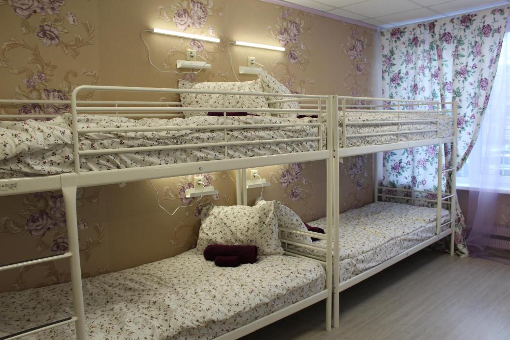 モスクワにあるHostel Nika-Cityの花柄の壁紙を用いた客室で、二段ベッド2組が備わります。