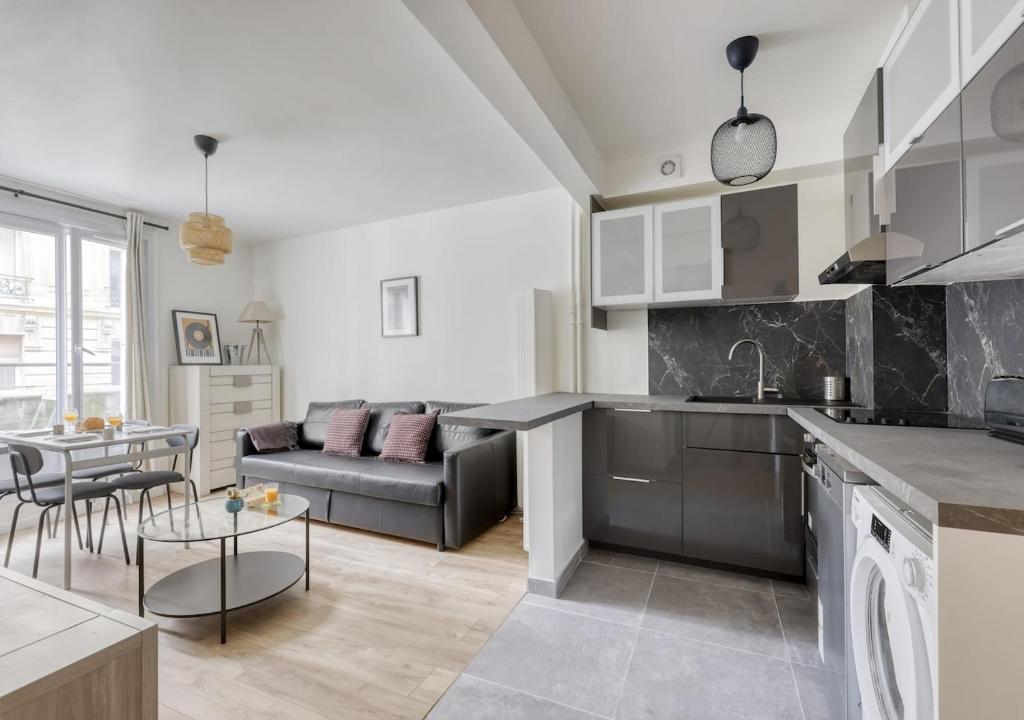 une cuisine et un salon avec un canapé et une table dans l'établissement Splendid 2bdrs Flat with Balcony-Paris 15 - Mid T, à Paris