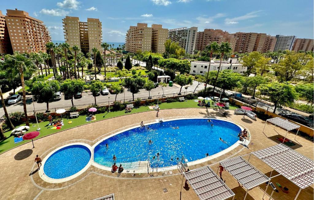 a large swimming pool in a park with a city at 2 Bedroom Nice Apartment In Oropesa Del Mar in Oropesa del Mar