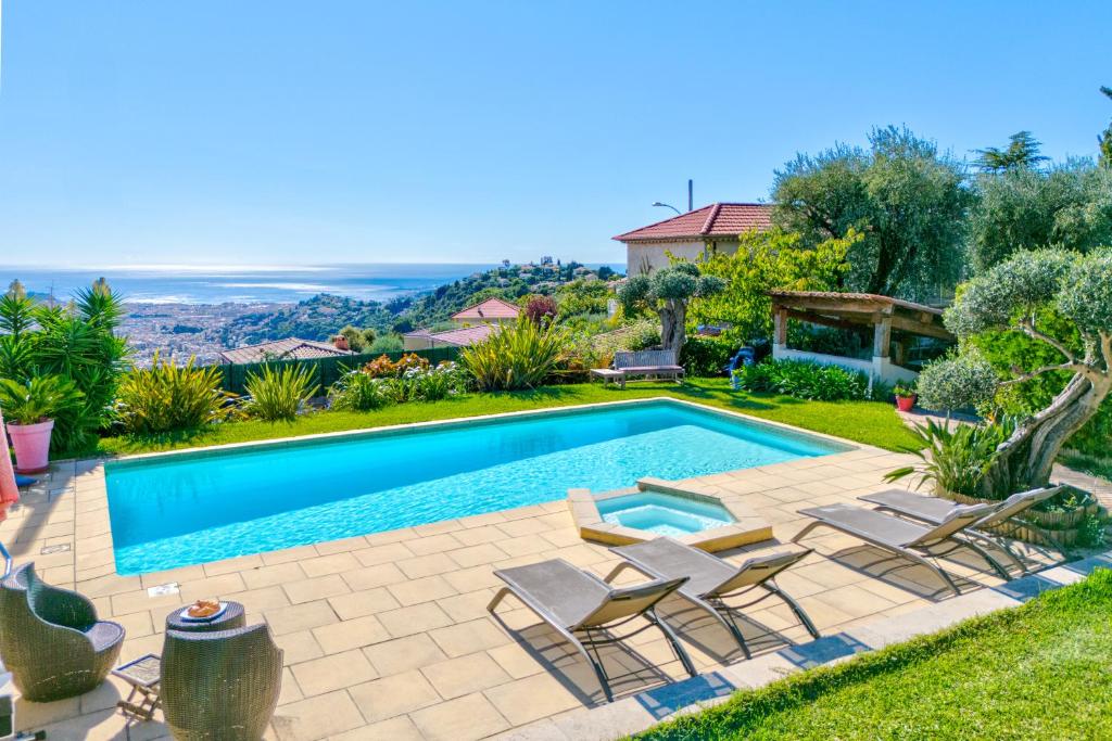 - une piscine dans un jardin avec des chaises et une maison dans l'établissement Villa de prestige Vue mer panoramique Piscine Climatisation, à Nice