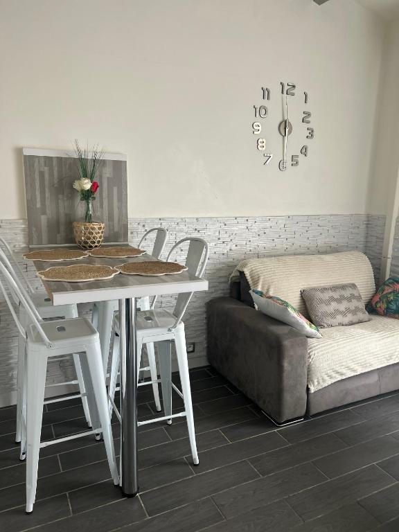 - une salle à manger avec une table, un canapé et un réveil dans l'établissement Appart port du cap d agde, au Cap d'Agde