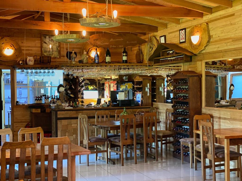 a restaurant with wooden tables and chairs and a bar at Hotel Boutique La Casa de Coco in Gorbea