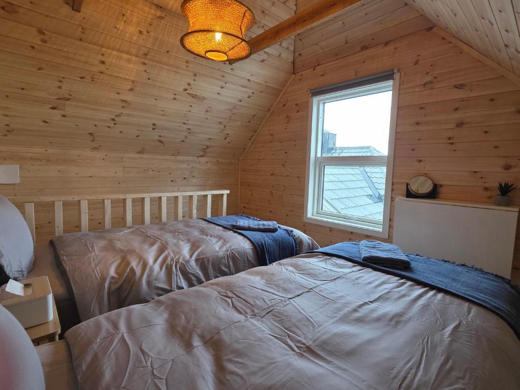 a bedroom with two beds in a wooden cabin at The Perfect Stop - Pinewood Loft in Lødingen