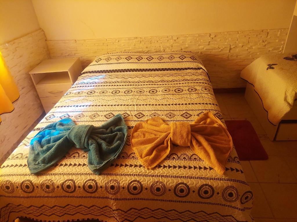 Una cama con dos pares de lazos encima en Alquileres temporarios Anahi, en Las Heras
