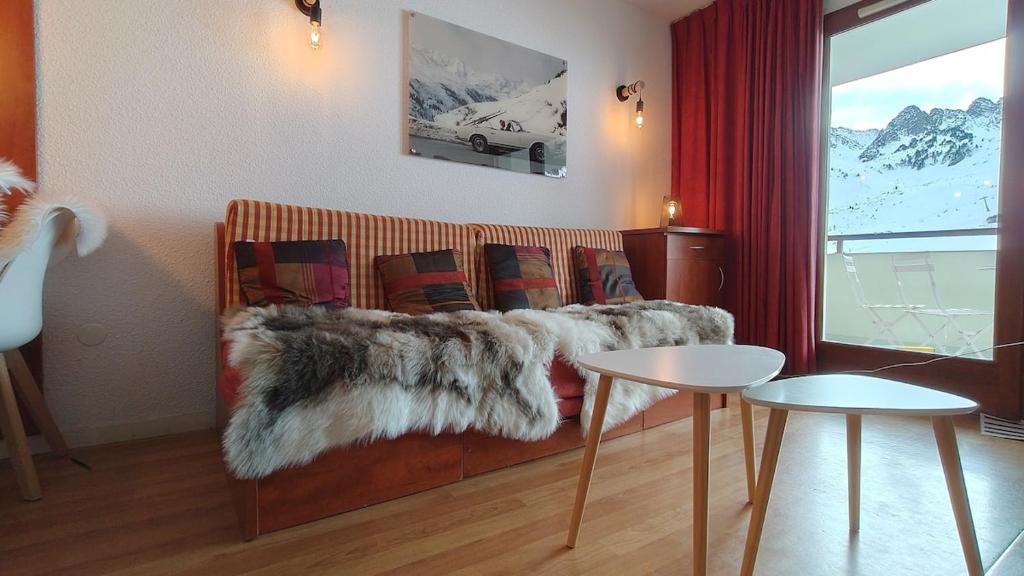 - un salon avec un canapé et une fausse couverture en fourrure dans l'établissement T2 piscine, terrasse, parking couvert Résidence Pic du Midi, à Bagnères-de-Bigorre