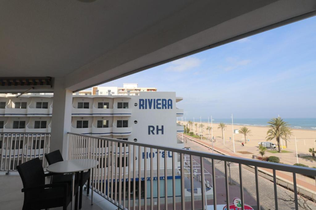 un balcon avec vue sur la plage et un hôtel dans l'établissement Primerísima Linea de Playa Gandía BONAIRE, à Puerto de Gandía