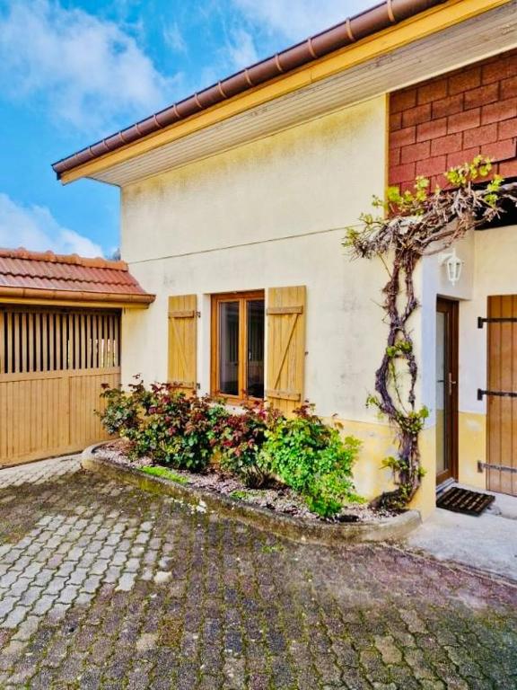 une maison avec un arbre devant dans l'établissement Très joli logement, à Anould