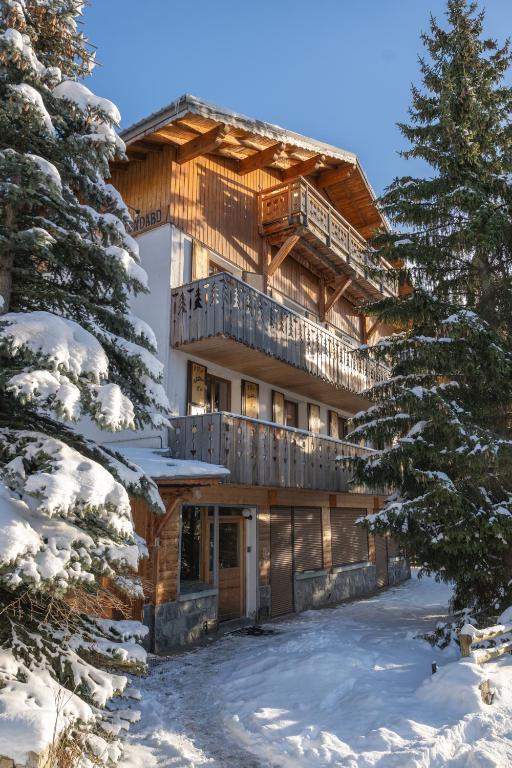 une maison en rondins dans la neige avec des arbres dans l'établissement Alpe Two - Sea and Mountain Pleasure 12P- Pieds des Pistes- Centre - Jacuzzi - Sauna - 5 Chambres - 5 Salle de bains, à L'Alpe-d'Huez