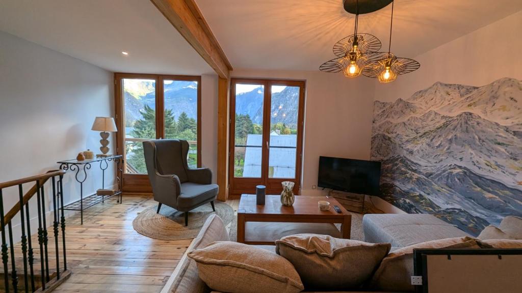un salon orné d'une grande peinture de montagnes sur le mur. dans l'établissement Immeuble Savonette, au Bourg-dʼOisans