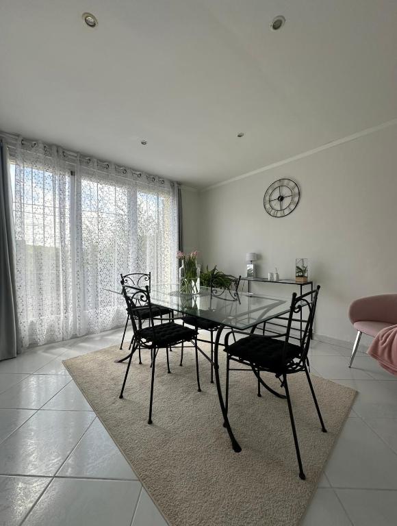 une salle à manger avec une table et des chaises en verre dans l'établissement Dolce casa Maison familiale, à Dourdan