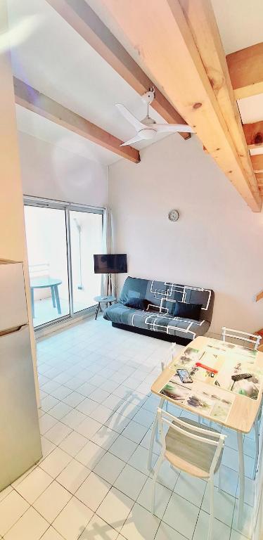 un salon avec une table et un canapé dans l'établissement Appartement T2 piscine et parking, au Cap d'Agde
