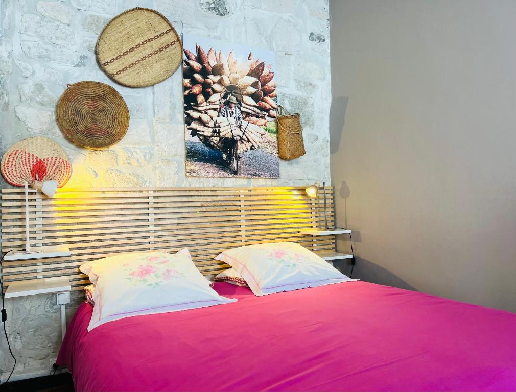 a bed with a pink blanket and two pillows at Souleiado St Rémy centre Tout Confort in Saint-Rémy-de-Provence