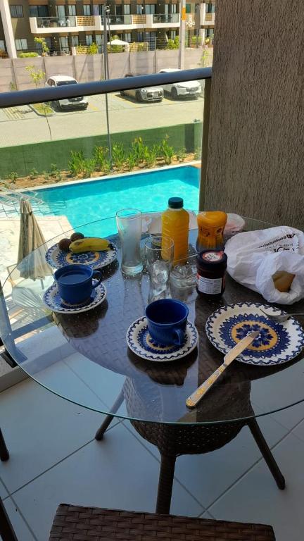 un tavolo con piatti di cibo e bevande sopra di Flat makia 123 C acessivel a Ipojuca