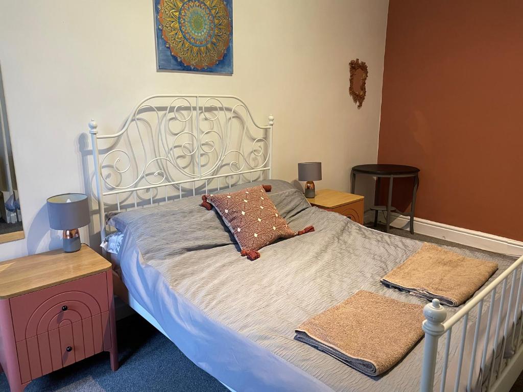 ein Schlafzimmer mit einem weißen Bett mit zwei Handtüchern darauf in der Unterkunft Apartment close to Pavilion gardens in Buxton