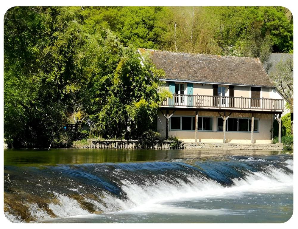 a house next to a river with a waterfall at Maison avec Jardin en bord de rivière in Fresnay-sur-Sarthe