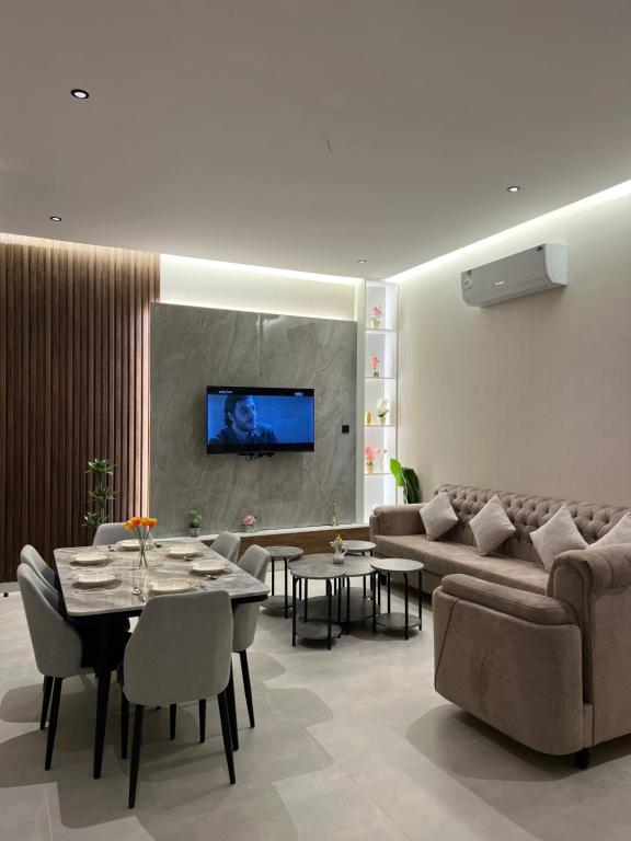 a living room with a couch and a tv on a wall at new Luxury Apartment near Masjid Quba in Al Madinah