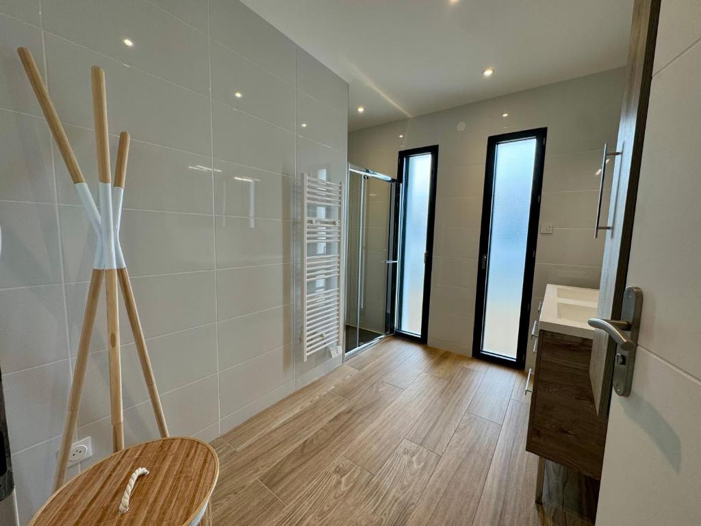 La salle de bains est pourvue d'une chaise en bois et d'un lavabo. dans l'établissement Maison Neuve 5 Personnes - Proche de la Mer - EXT, à La Tranche-sur-Mer