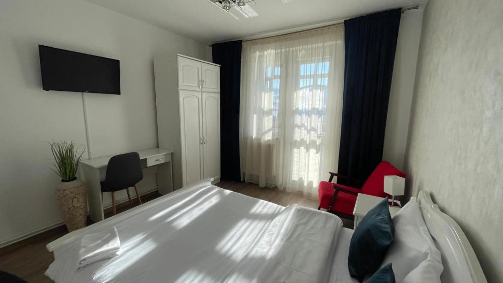 a bedroom with a white bed and a window at Apartament Panoramic Toplița in Topliţa