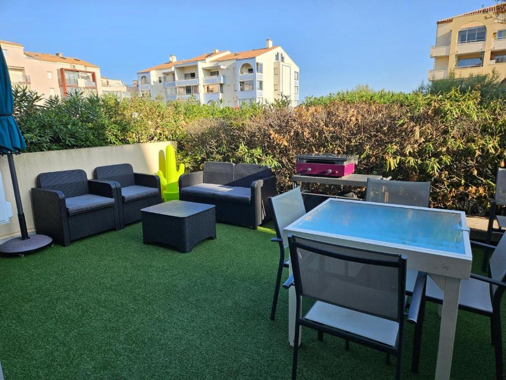 d'une terrasse avec des chaises, une table, une table et des chaises. dans l'établissement Location Frontignan Plage, à Frontignan